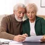Pareja de adultos mayores revisando documentos sobre pensión y ahorros previsionales en Chile