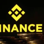 Logo de Binance junto a monedas que representan criptomonedas, tras el hackeo al exchange