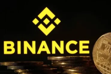 Logo de Binance junto a monedas que representan criptomonedas, tras el hackeo al exchange