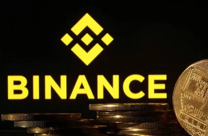 Logo de Binance junto a monedas que representan criptomonedas, tras el hackeo al exchange
