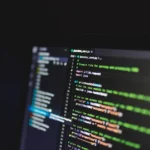 Pantalla de computador con código, brecha de datos y protección de la información personal