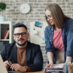 Emprendedores revisando las finanzas de su negocio frente a un computador